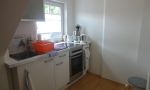 kleiner Küchenbereich mit Kühlschrank und Backofen